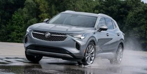 Silver 2022 Buick Envision driving through a puddle of rain.
