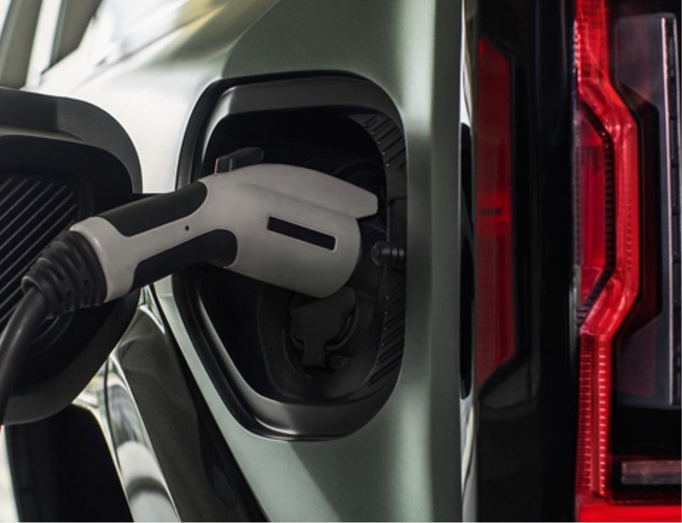 Close up of charging port with charger plugged in on a GMC Hummer EV SUV - Randy Wise Buick GMC in Fenton MI